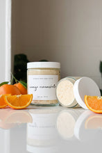 Load image into Gallery viewer, Jar of orange creamsicle body scrub with a white lid on a reflective surface.